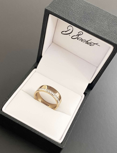 A flat and wide eternity wedding ring for women, in yellow gold and white diamonds.