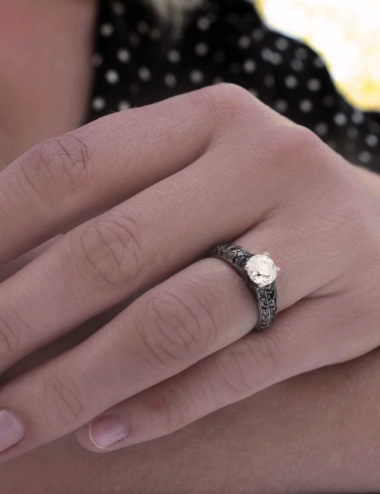 Platinum women's engagement ring with a 0.80-carat white diamond and black diamonds.