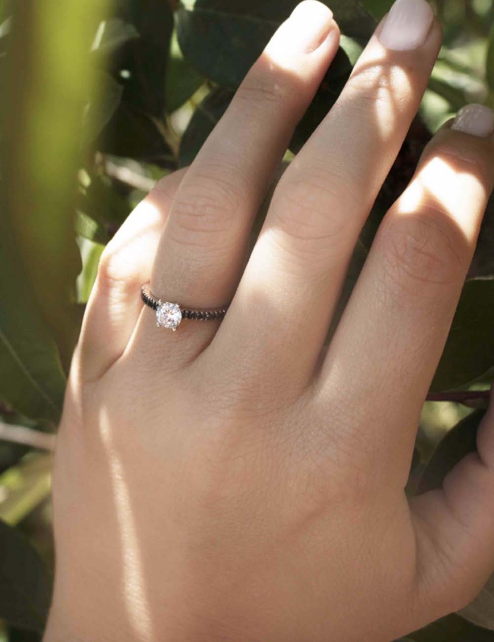 Engagement ring: platinum, central white diamond, black diamond pavé, prong setting.