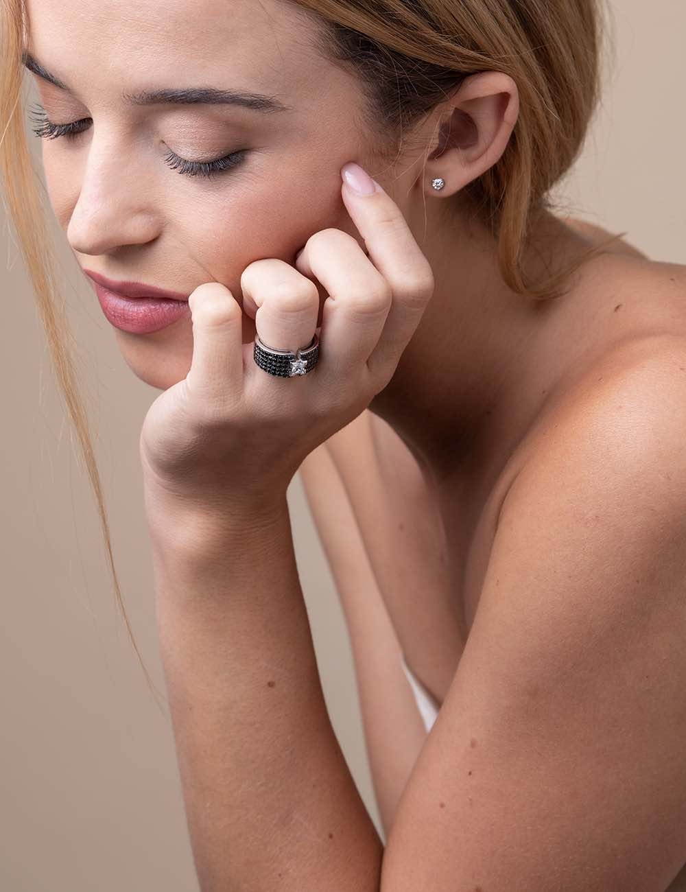 Bague luxe femme: diamant blanc princesse 0.60 ct, entouré de diamants noirs.