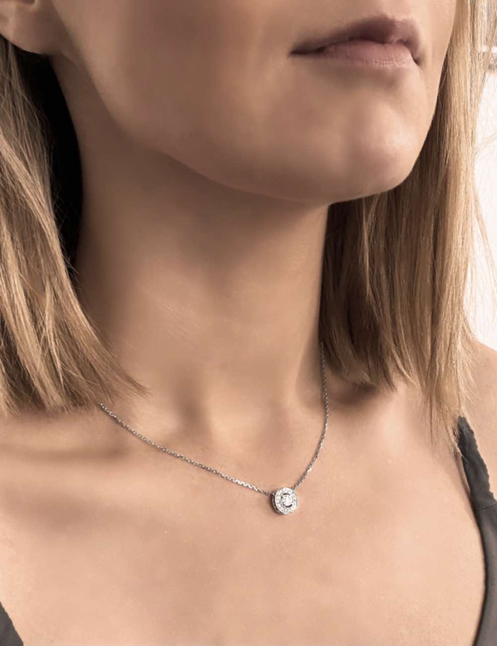 Collier luxe pour femme, un diamant blanc de 0.40 carat magnifié par un entourage de diamants.