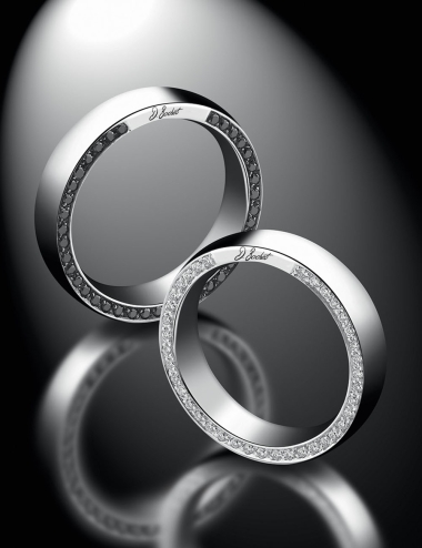 A modern and wide wedding ring set with white diamonds and black diamonds on the sides.