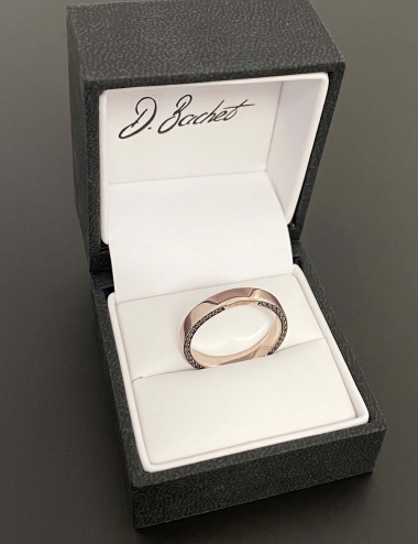 Wedding ring in rose gold set with white diamonds and black diamonds on the sides of the band