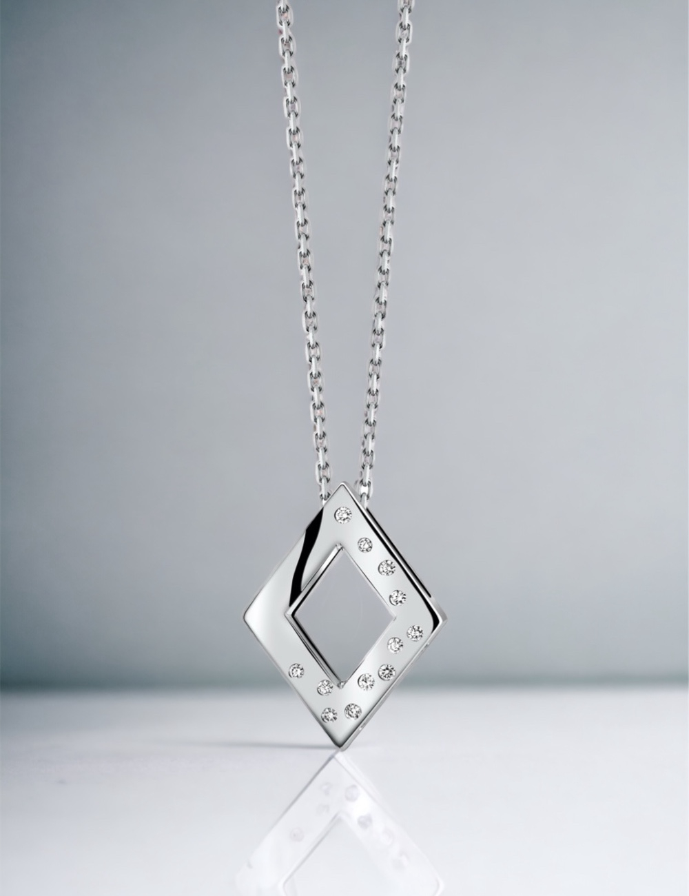 A women's pendant in a diamond shape, made of gold and adorned with white diamonds, suitable for everyday wear.