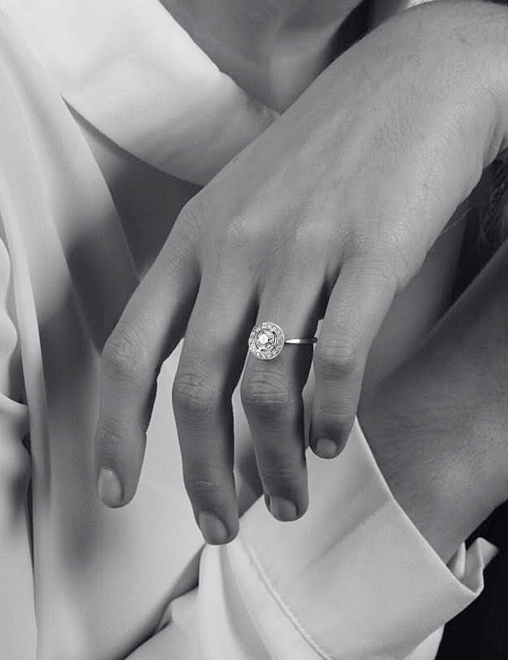 Bague de fiançailles 'About the Love' en platine avec diamant central et halo de diamants.