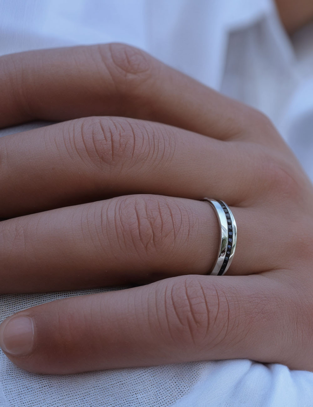 Bague de mariage homme élégante et moderne de D.Bachet, en platine et diamants noirs, fabriquée sur-mesure en France.