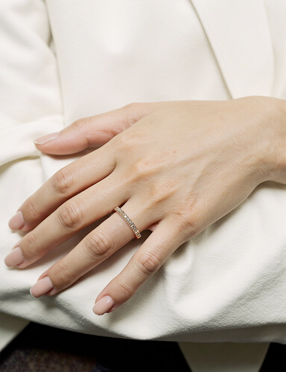 Yellow or rose gold diamond band with prongs, worn on hand, warm glow and elegant finish.
