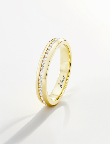 Yellow gold wedding band with channel-set diamonds, minimalist D.Bachet design.
