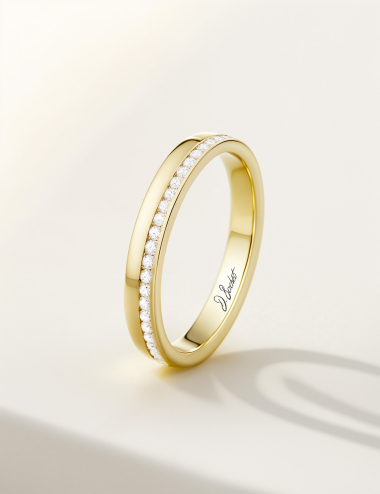 A thin and flat yellow gold women's wedding band with white diamonds.