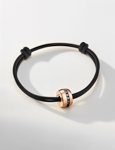 Rose gold men’s bracelet set with black diamonds, on a black cord with sliding knots.