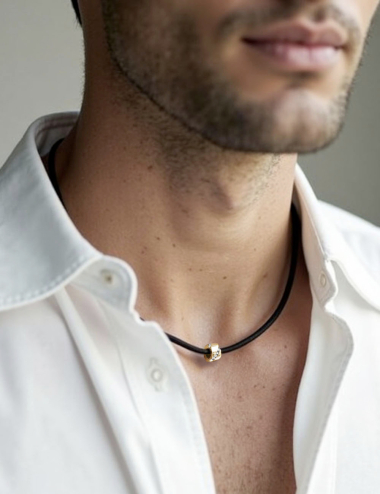 Collier homme en or jaune et diamant blanc, sur cordon noir avec fermoir doré raffiné.