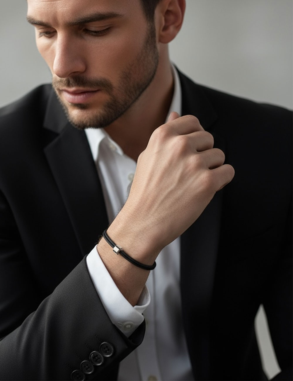 Bracelet contemporain pour homme en or blanc 750, orné de diamants noirs, monté sur un cordon en coton noir ajustable.
