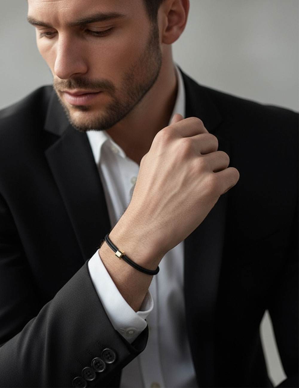 Bracelet homme A Bridge to Unity en or jaune serti de diamants noirs, monté sur cordon noir ajustable.