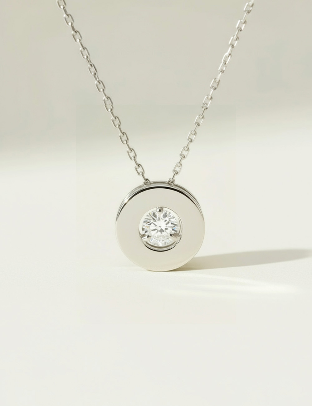 Collier en or blanc avec diamant central en lévitation, création joaillière D.Bachet raffinée.