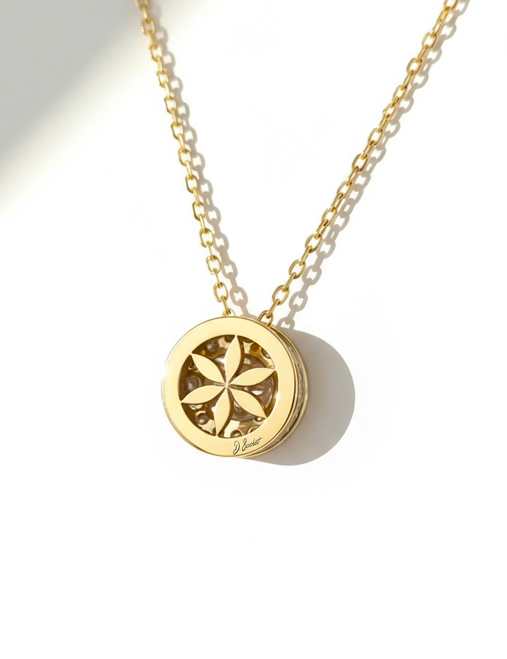 Collier en or jaune avec diamant blanc de 0,20 carat, fleur de vie ajourée au dos, création joaillière D.Bachet.