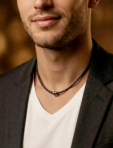 Men’s yellow gold pendant with black diamonds on a black cord, modern and refined design.