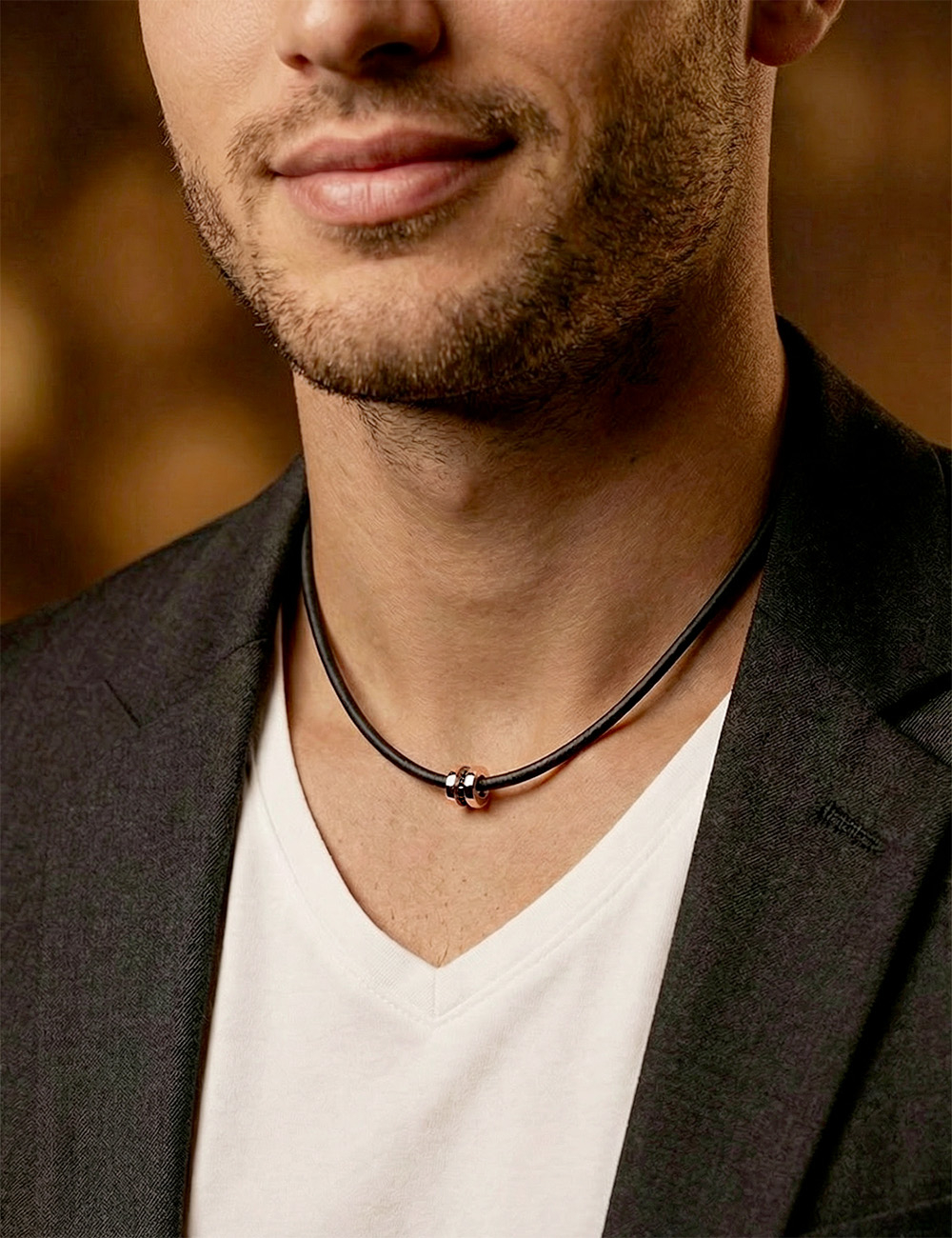Rose gold pendant with black diamonds on black cord, graphic men’s jewelry design.