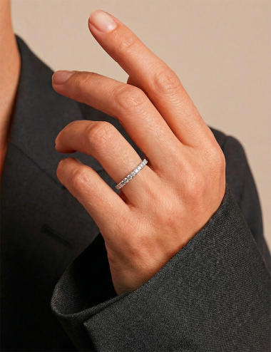 Platinum diamond wedding band with prong setting, worn on hand, sleek and timeless design.