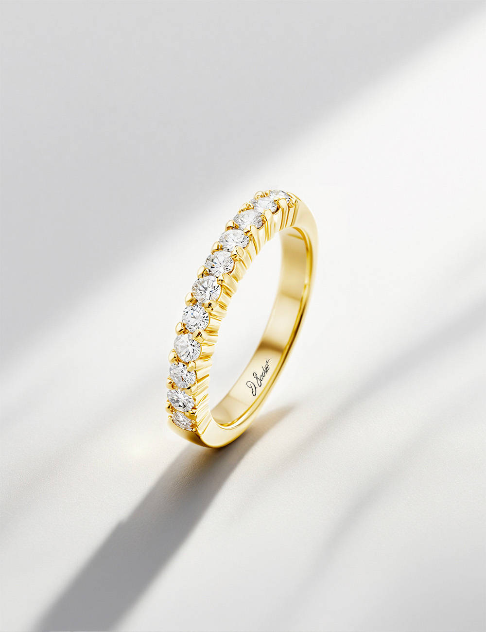 Women’s yellow gold wedding band with natural white diamonds in a prong setting, a refined and luminous D.Bachet design.