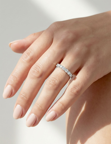 Platinum women's band with natural white diamonds in claw setting, modern luminous ring design.