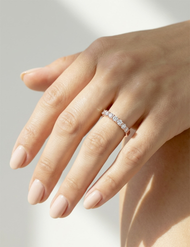 Rose gold women’s band with natural white diamonds in claw setting, elegant soft-toned bright ring.