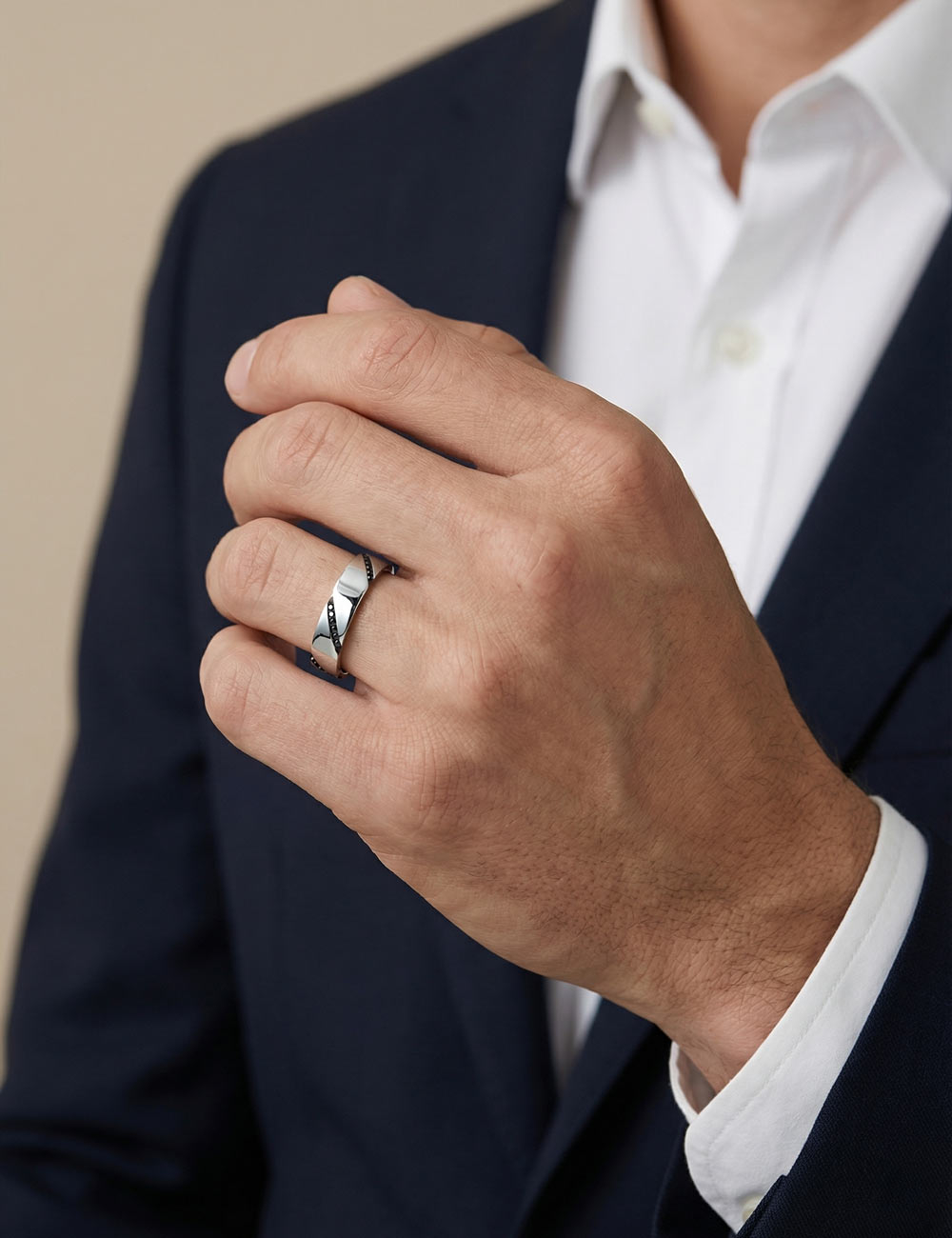 Men’s platinum wedding band with black diamonds set in diagonal lines, contemporary design, worn on the ring finger.