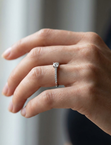 Bague de fiançailles en platine sertie de sept diamants blancs, diamant central 0,50 ct, lignes épurées et contemporaines.