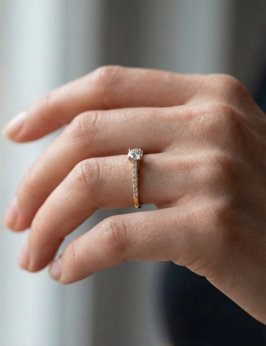 Yellow gold engagement ring with a 0.50 carat center diamond and seven white diamonds, contemporary fine jewelry design.