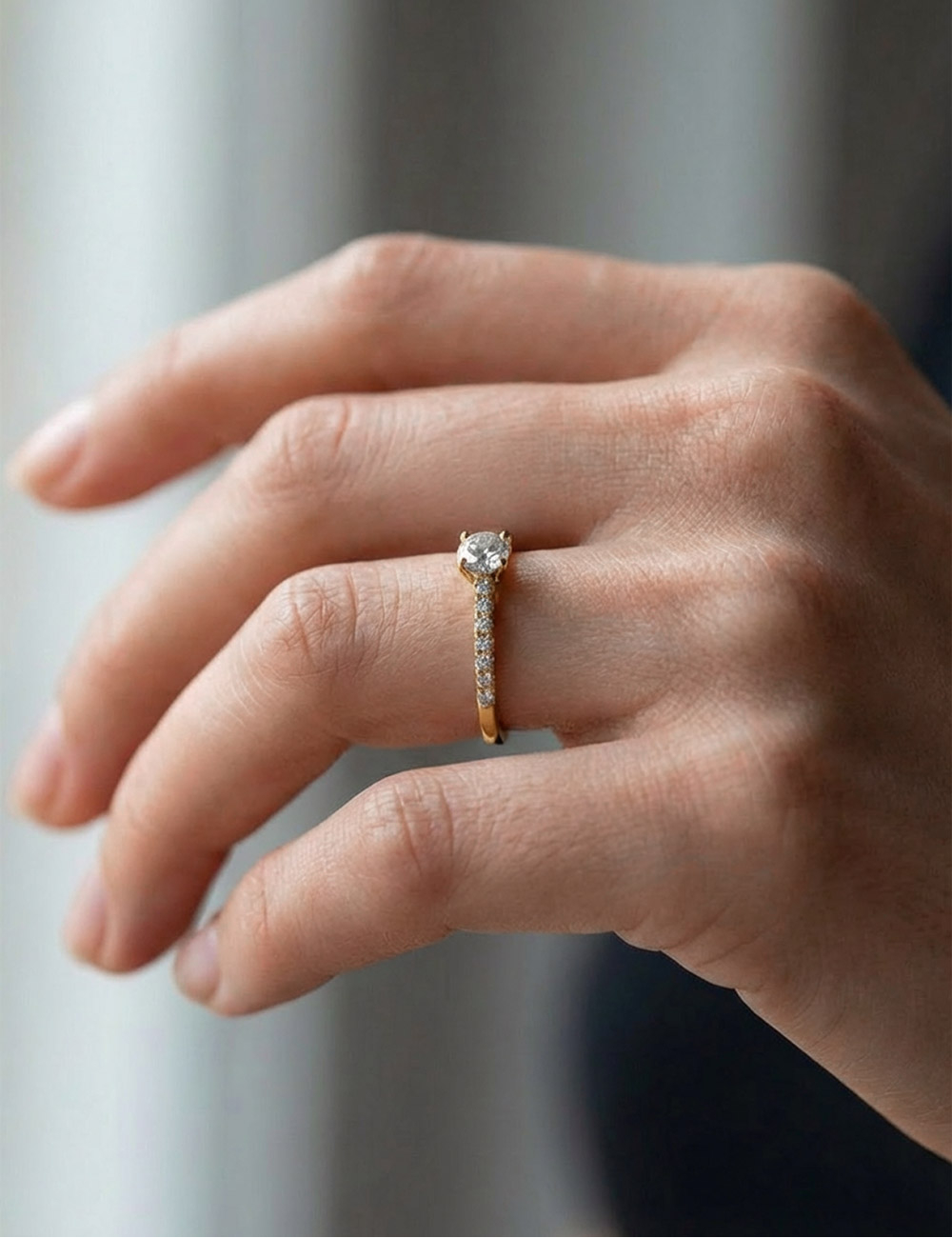 Yellow gold engagement ring with a 0.50 carat center diamond and seven white diamonds, contemporary fine jewelry design.