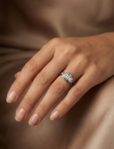 Bague L’Origine portée au doigt, bague Haute Joaillerie D.Bachet en platine et diamants noirs et blancs.