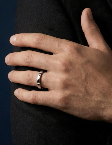 Structured platinum men’s wedding band with black diamonds on sides and surface.