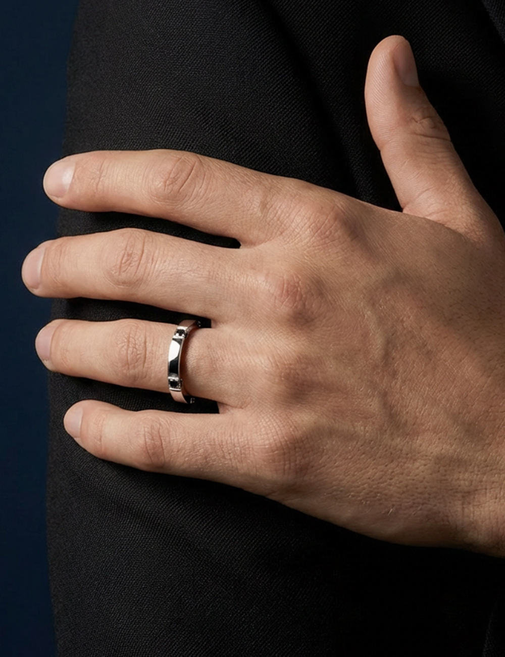 Structured platinum men’s wedding band with black diamonds on sides and surface.