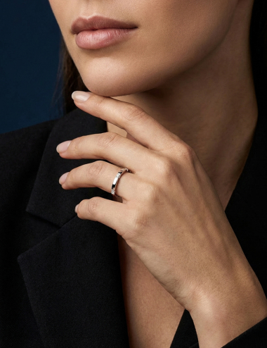 Structured platinum women’s wedding band with white diamonds on edges.