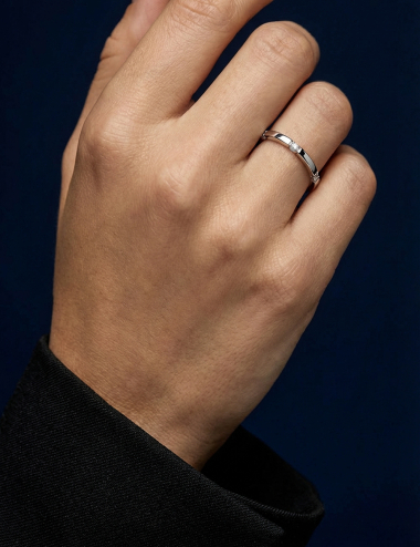 Modern women’s platinum band with bead-set white diamonds on top and sides.