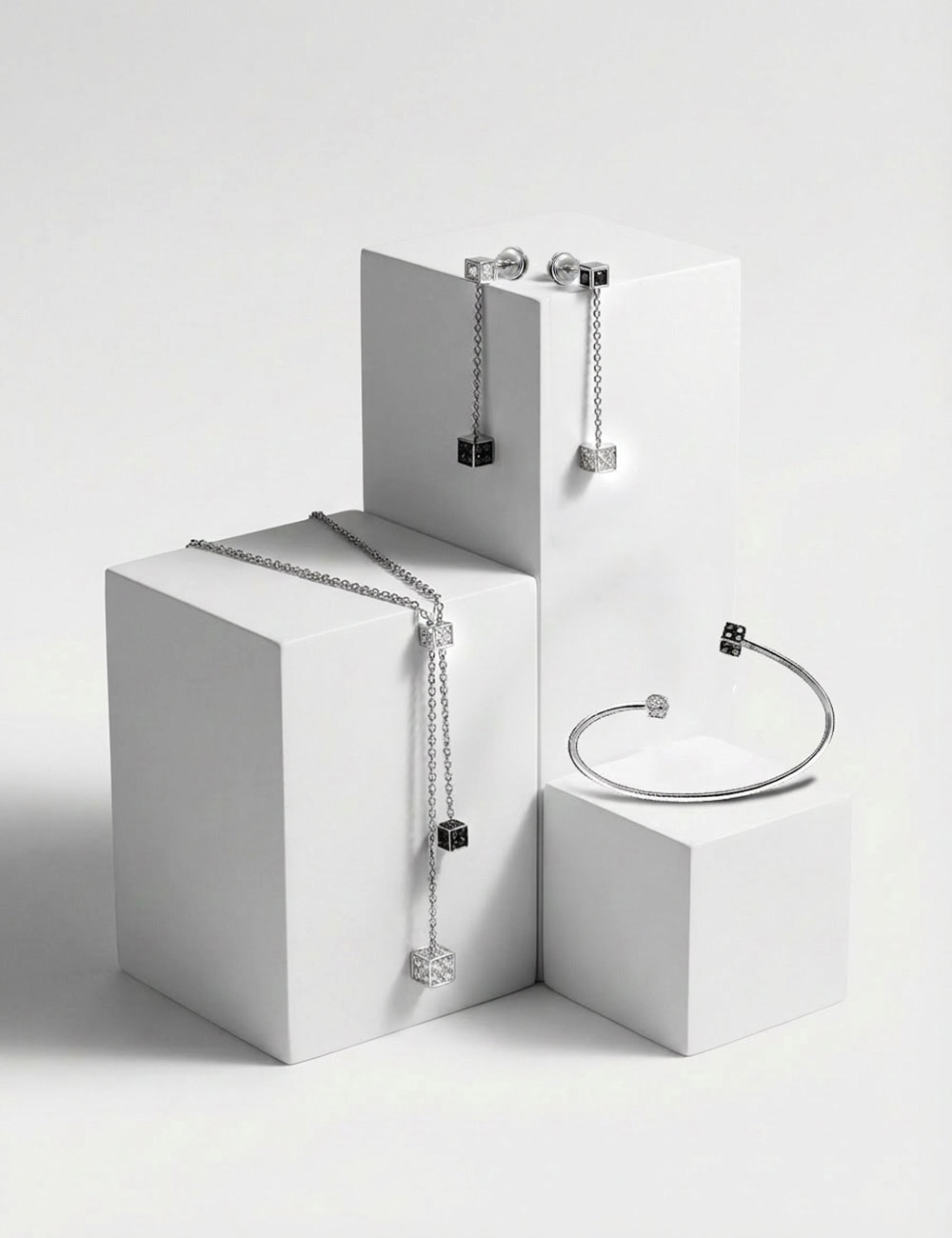 White gold cube jewelry set with black and white diamonds including necklace, bracelet and earrings by D.Bachet.