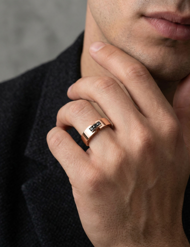Men’s 18k rose gold ring set with three black diamonds worn on hand, architectural design by D.Bachet.