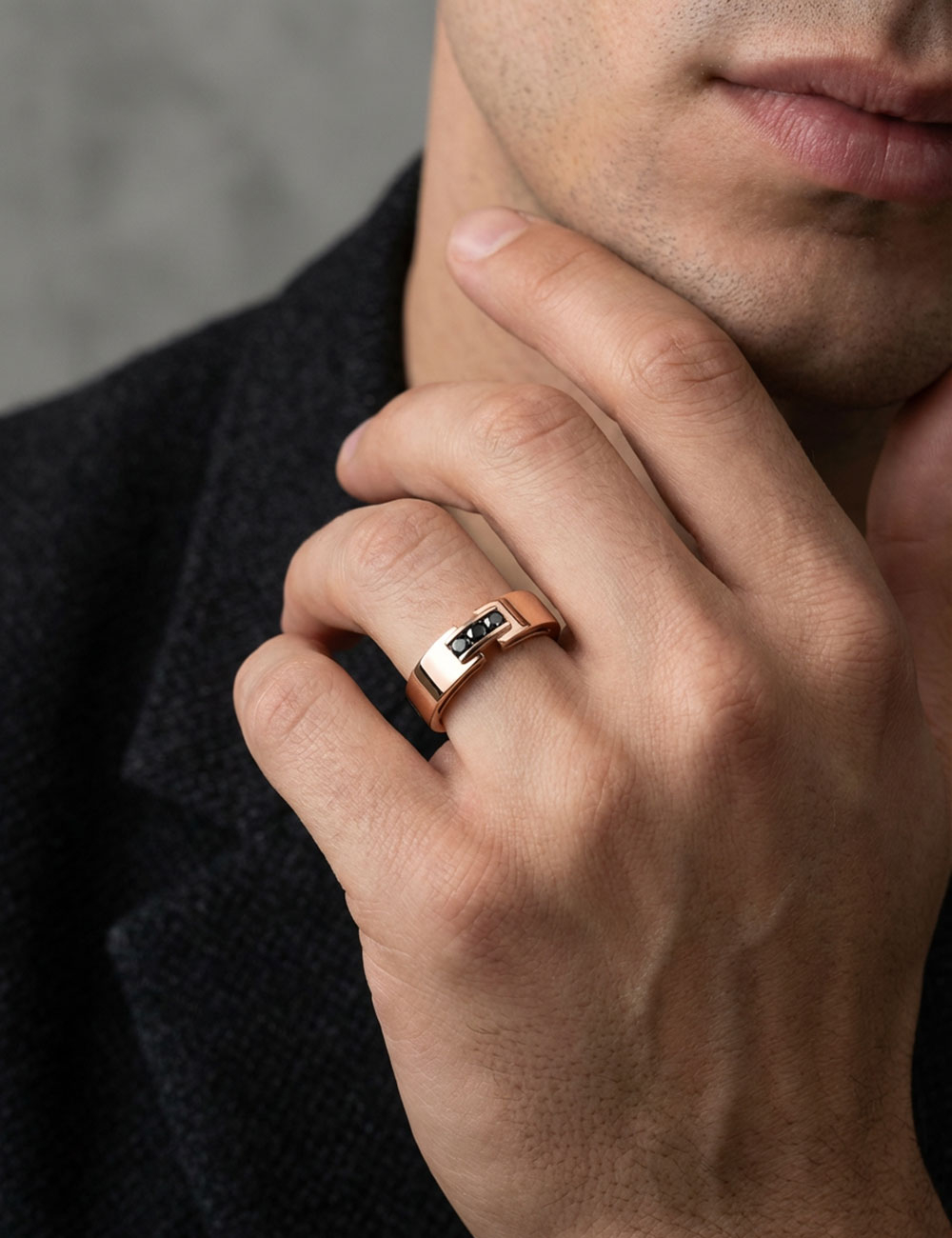 Men’s 18k rose gold ring set with three black diamonds worn on hand, architectural design by D.Bachet.