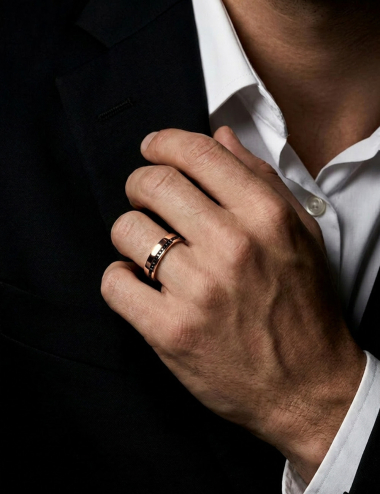 Men’s rose gold wedding band with an offset line of black diamonds, contemporary design, worn.