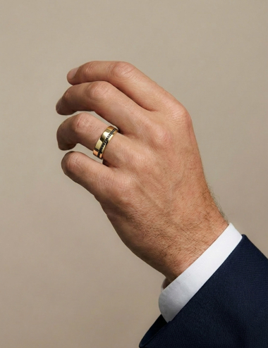 Alliance homme Sweet Side of Love en or jaune 6 mm avec diamants noirs, portée sur la main.