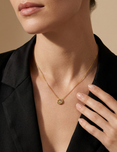 Pendentif Aura en or jaune 18 carats et diamant blanc, porté avec veste noire. D.Bachet.