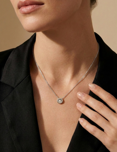 Aura pendant in 18k white gold with white diamond, worn with black blazer. D.Bachet.