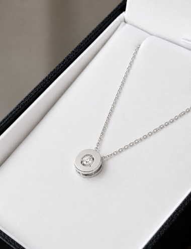 White gold Aura necklace with central diamond, displayed in its jewelry box.