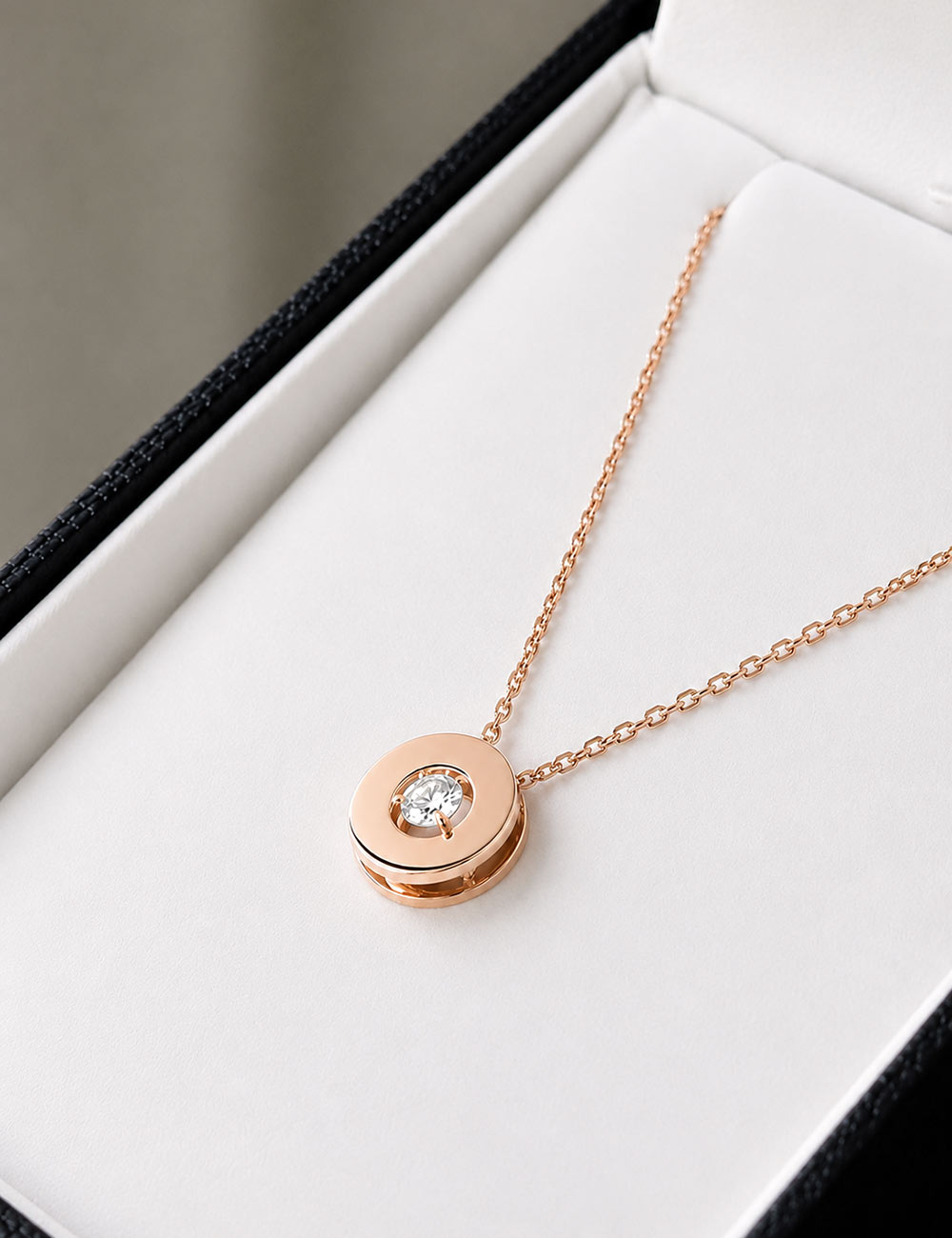Collier Aura en or rose avec pendentif rond épuré et diamant solitaire.