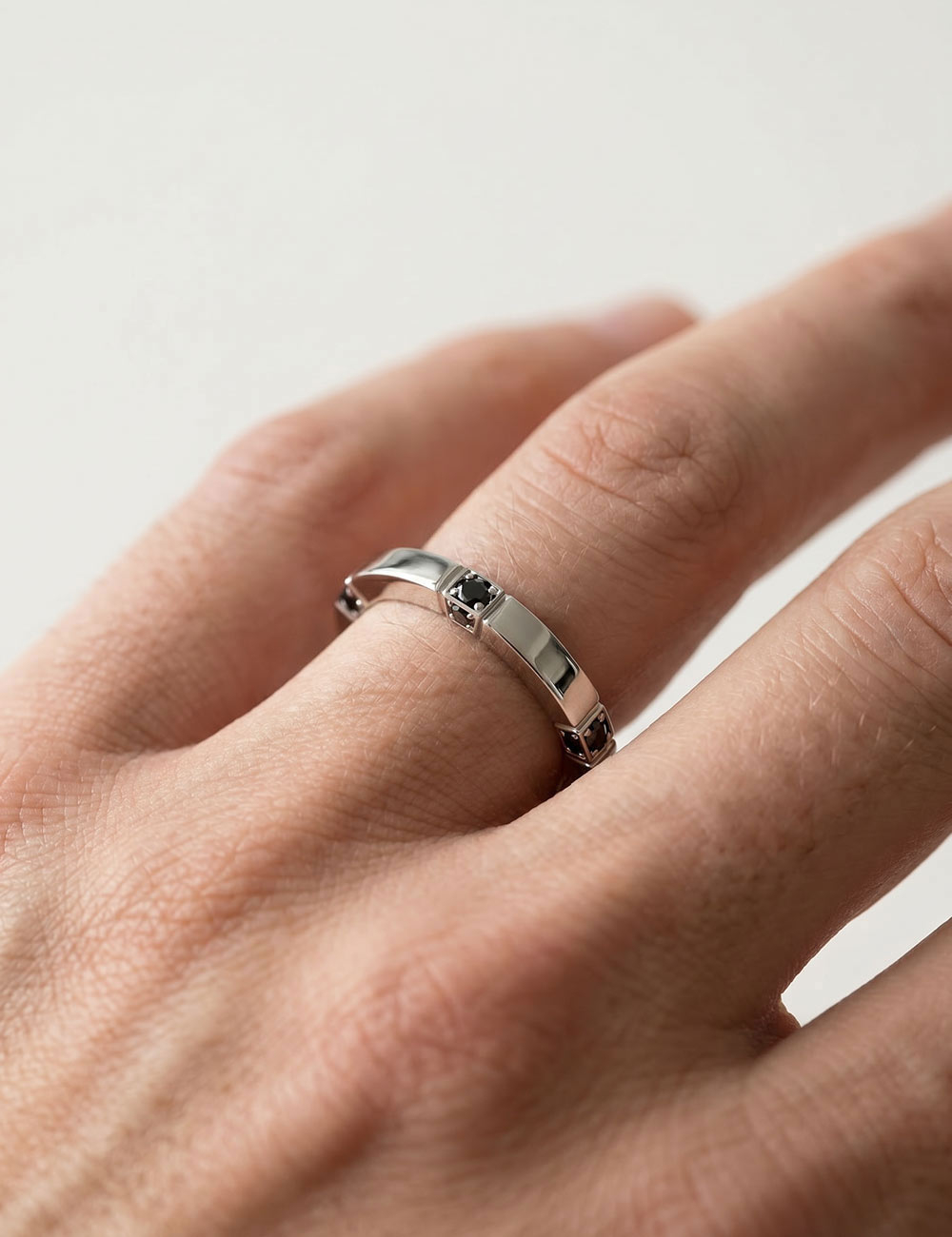 Alliance homme Gravity en platine 950 sertie de diamants noirs sur le dessus et les tranches.
