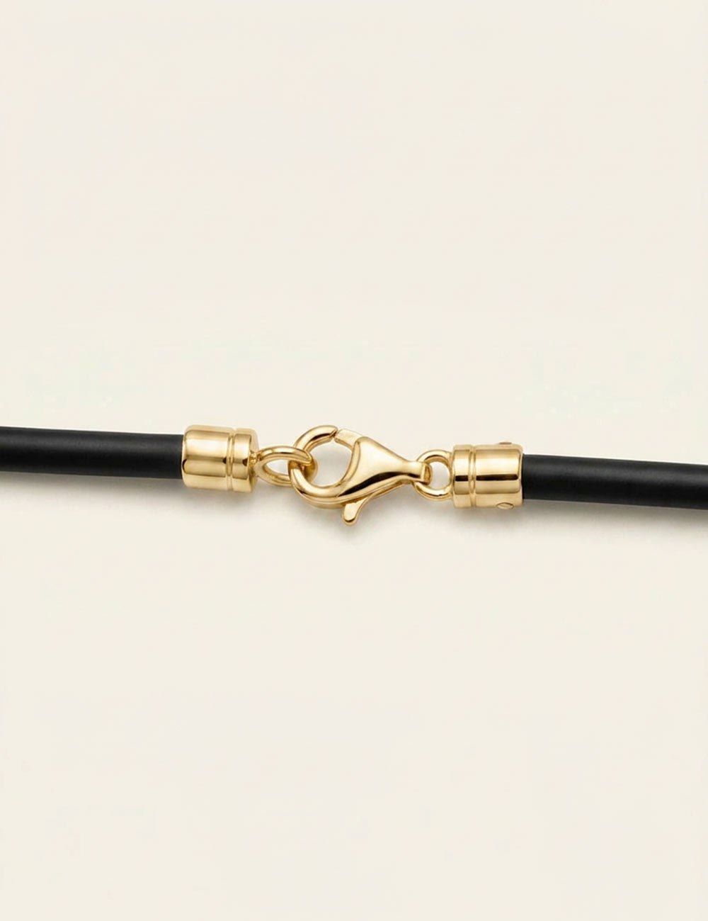 18k yellow gold lobster clasp on black silicone cord, luxury jewelry by Maison D.Bachet.