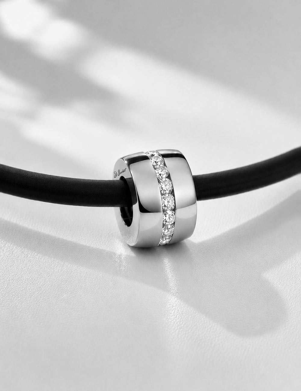 D.Bachet A Way to Love men's pendant in 18k white gold and channel-set white diamonds, on a matte black silicone cord.