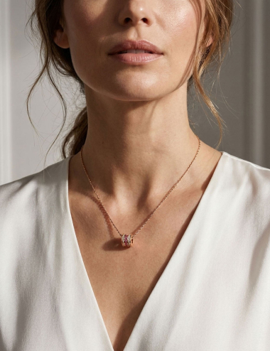 Pendentif Scroll in Love en or rose 18 carats, serti de saphirs roses et diamants blancs, porté sur une femme.