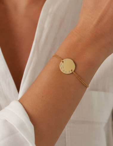 Cascade Medallion bracelet in 18K yellow gold set with white diamonds, worn on the wrist.