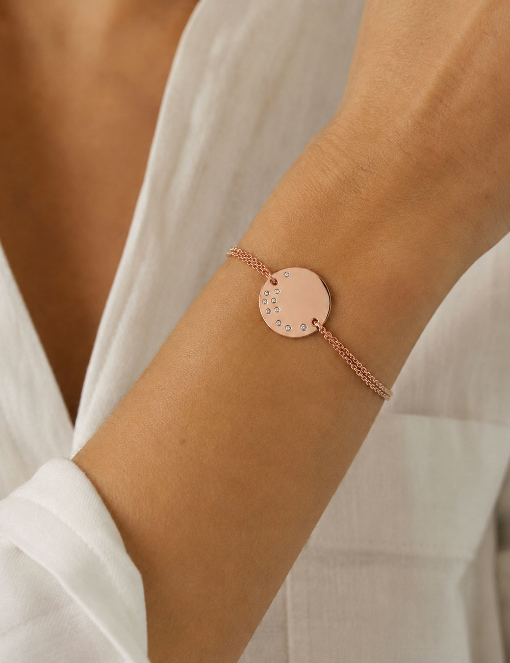 Cascade Medallion bracelet in 18K rose gold set with white diamonds, worn on the wrist.