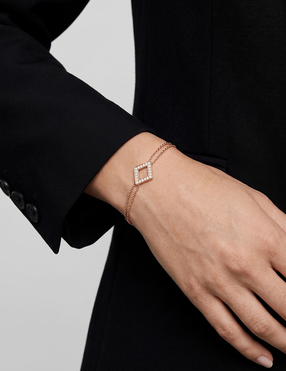 Women's 18K rose gold bracelet with double chain and diamond-shaped motif set with natural white diamonds.